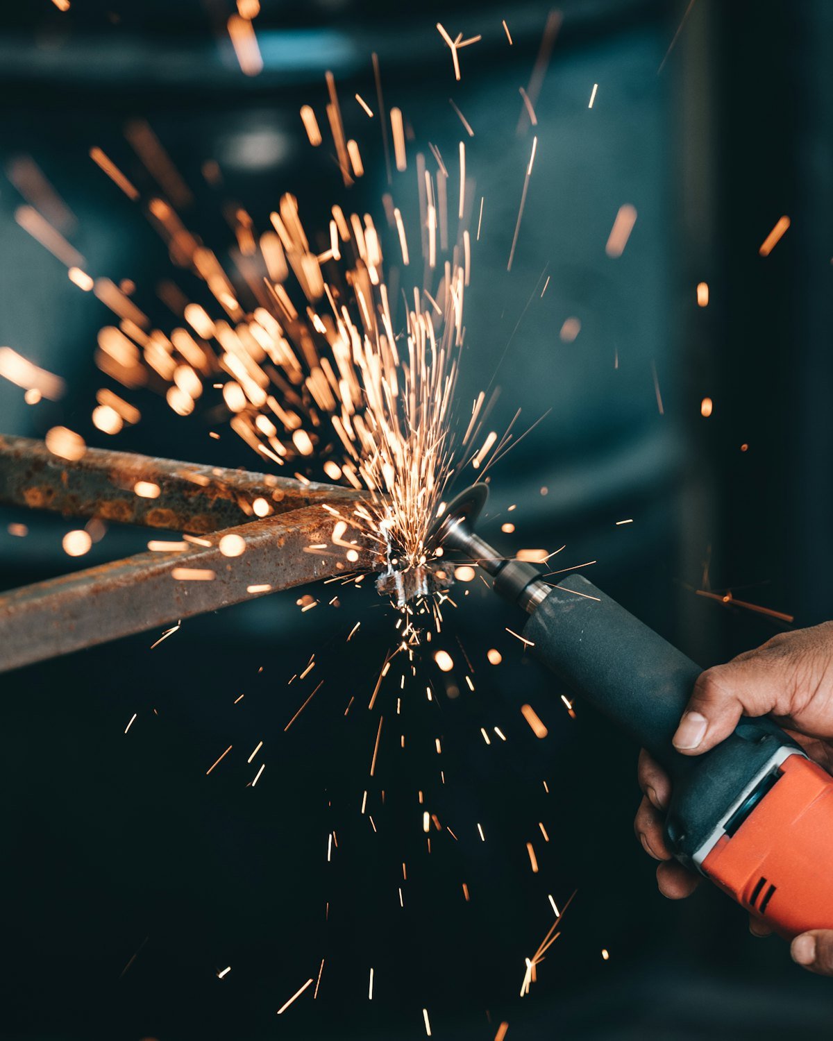 Workshop fitter grinding a steel pump baseplate